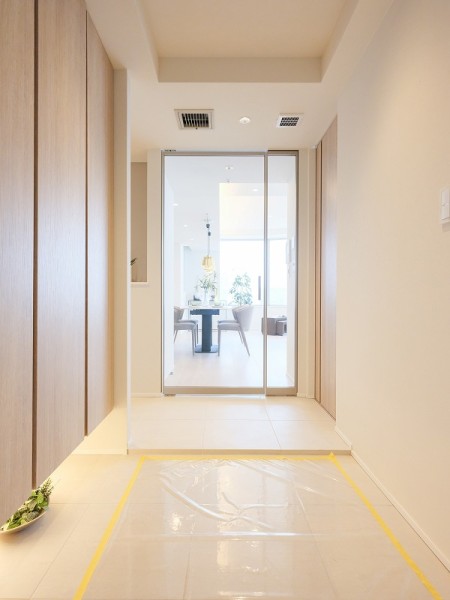 廊下とリビングを繋ぐ建具は、洗練されたシャープなフレームとガラスのコンビネーションが美しい、Raiki製を採用しました。リビングからの光を取り込んだ明るい玄関を創り出します