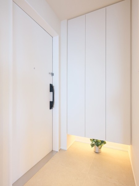 清潔感のある玄関は、フットライトからのびる光が足元を優しく包み込みます。天井までの高さがあるシューズボックスを備え付けたので、玄関をすっきり綺麗に保てます。