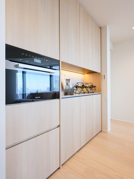 ビルトイン型のMiele製電子オーブンを採用したカップボード。すっきりとした収納と美しいライティングで、キッチン全体をワンランク上の空間にします。