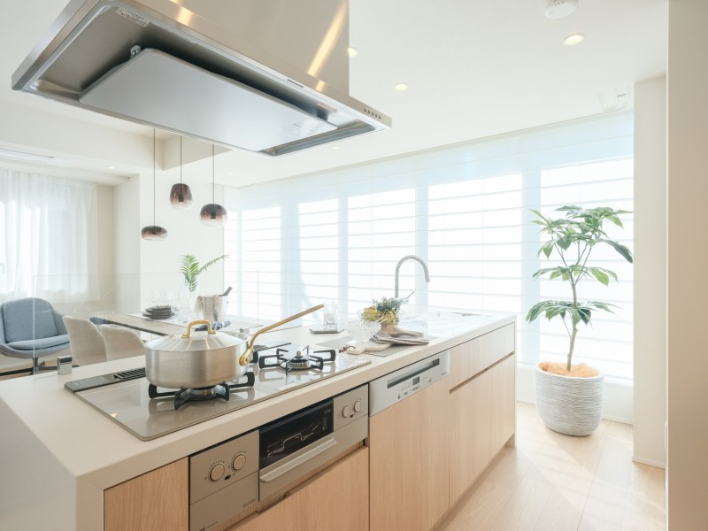 田中工藝製の美しいアイランドキッチンが、住まいの中心に。Mieleの食洗器も搭載し、機能性とデザイン性を両立。開放的な空間で、調理から食事、会話まで、家族の豊かな時間を育みます。