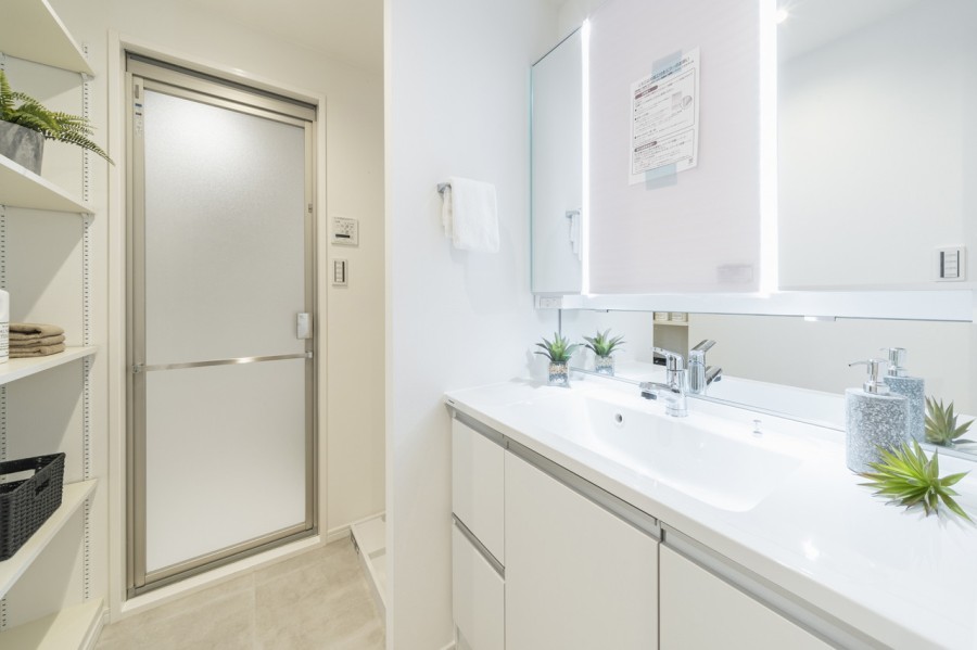 Panasonic製の洗面化粧台は、白を基調とした明るく清潔感のある空間です。三面鏡裏や足元の収納など使いやすさも兼ね備えています。