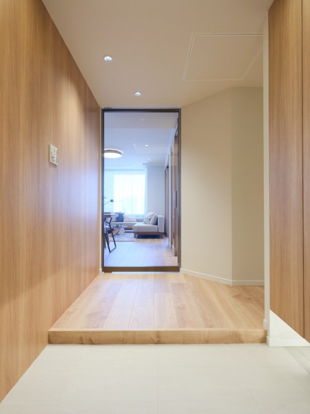 ダイニングからも光を取り込む明るい玄関スペースです。木のぬくもりを感じるナチュラルテイストに上質感を加えた気品溢れる空間です。