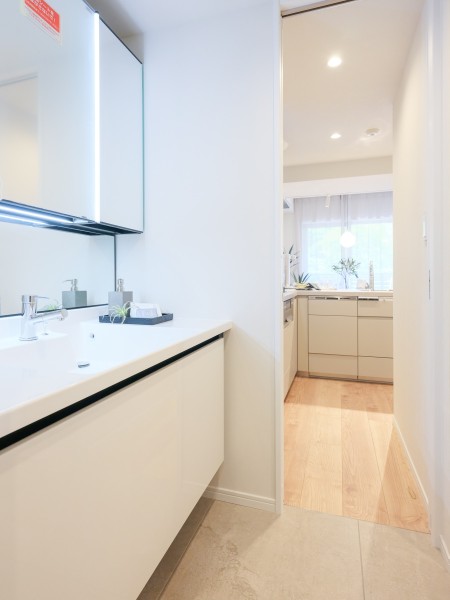 白を基調とした清潔感溢れるデザインの洗面化粧台です。帰宅して手を洗い、そのままキッチンへのアクセスも可能♪動線も収納棚を備え付けたので、細々したものが多くなる洗面室もすっきり保てそうです。