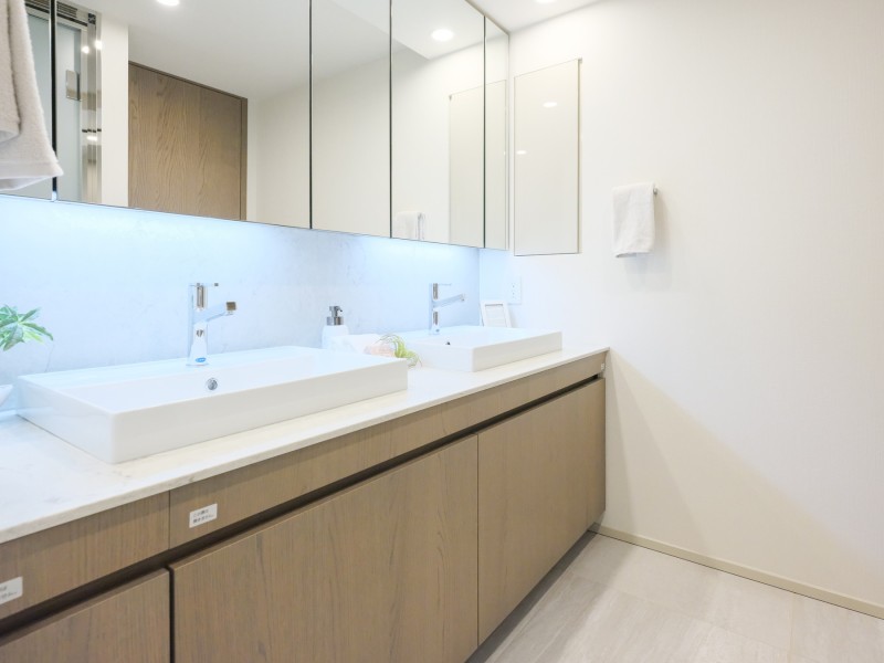 ホテルライクなダブルボウルの洗面台は、大きな鏡で身だしなみも整えやすく、朝の慌ただしい時間帯も快適にお使いいただけます。タオルや着替えなどを収納できるリネン庫も備わっています。