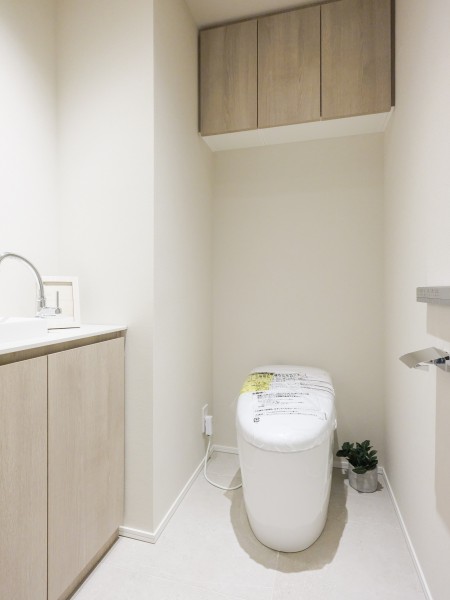 レストルームはスマートなタンクレストイレと手洗いカウンター、上部吊戸棚収納を設置しています。