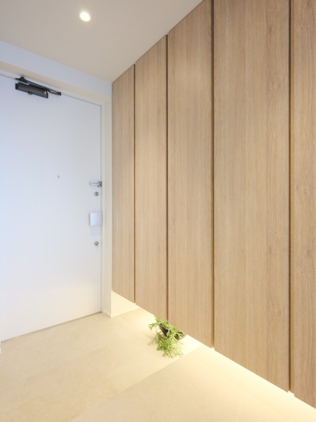 フットライトからのびる光が足元を優しく包み込む玄関です。人感センサー付きライトを設置したので、暗い時間帯のご帰宅や両手が塞がっているときも快適です。