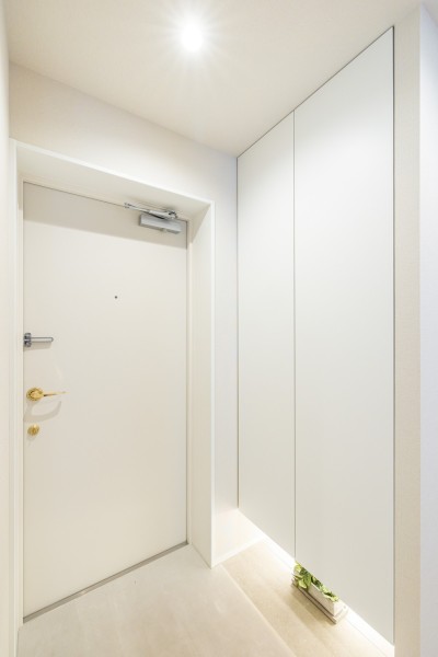 清潔感のある玄関は、フットライトからのびる光が足元を優しく包み込みます。天井までの高さがあるシューズボックスを備え付けたので、玄関をすっきり綺麗に保てます。