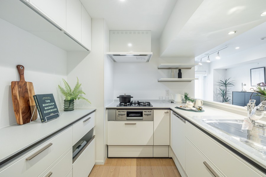 ミルクホワイトのシステムキッチンは機能性とデザイン性を兼ね備えた仕上がり。動線も快適で、家事時短に便利な食洗器を搭載しています。