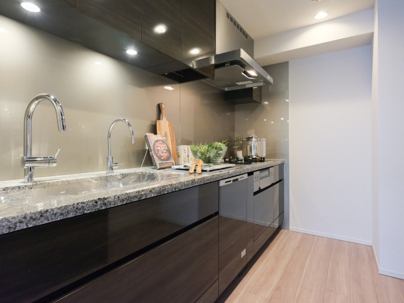 快適な家事動線が確保された壁付けシステムキッチンです。背面にはキッチンとお揃いで収納豊富なカップボードが備わっています。