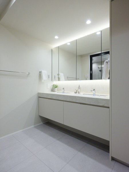 大きな鏡が印象的なラグジュアリーな洗面室です。キッチンと同じ田中工藝製のオリジナル洗面化粧台を採用しました。ホテルライクな2ボウルの洗面化粧台も見どころです。