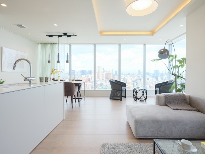 ワイドコーナーサッシから開放感がある眺望が望める、約24.3帖の居心地の良い広さのあるリビングダイニングキッチンです。折り上げ天井に間接照明が設置された気品溢れるリビングダイニングキッチンです。