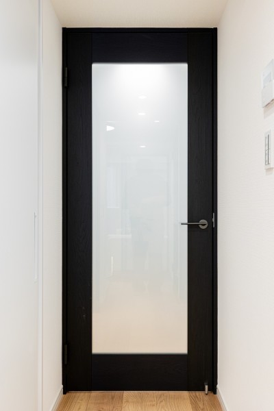 廊下とリビングダイニングキッチンを仕切る扉のフレームには、空間を引き締めるアクセントになるブラックを採用しました。