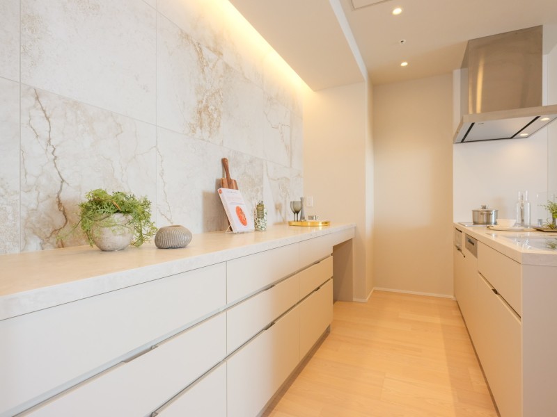 キッチン背面には収納豊富なカップボードがあります。流れ目の美しいタイルと間接照明が、よりいっそう上質空間を創り出す気品溢れるキッチンです。