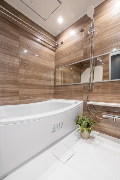 心と身体と向き合うセルフケアが叶うバスルームです。光沢感のある木目調のパネルが、より一層くつろぎと高級感を醸し出します。