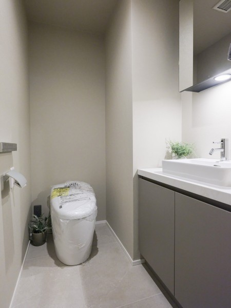 洗練されたお部屋にぴったりなスタイリッシュなタンクレストイレが設置されています。手洗い場や収納に便利なカウンターも備え付けです。
