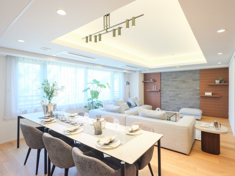 ホワイトカラーのクロスと木目調のフロアー材がお部屋を明るくし、格調高い雰囲気を作り出しています。織り上げ天井からは柔らかい色合いの間接照明がお部屋を温かく照らしており、気分を明るくさせます。