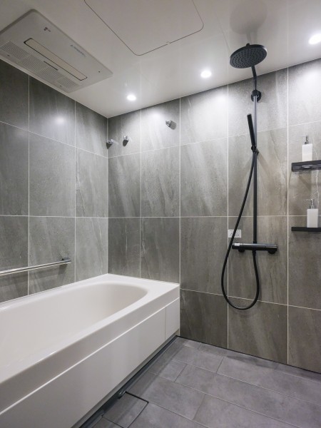 シックなカラーのこちらはバスルームとなっております。広々としたバスタブが映える色調のタイルを使用し、スタイリッシュな空間となっております。ゆとりのある浴室で、快適なバスタイムをお楽しみいただけます。