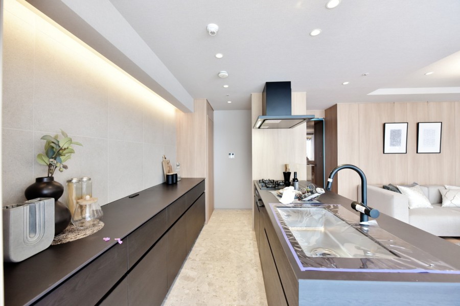 キッチンに合わせて田中工藝製の大容量のカップボードを備えつけました。キッチン家電や食器類もたっぷりと収納でき、すっきりと整頓された空間を保てます。間接照明がタイルを照らし、エレガントな空間を演出しています。