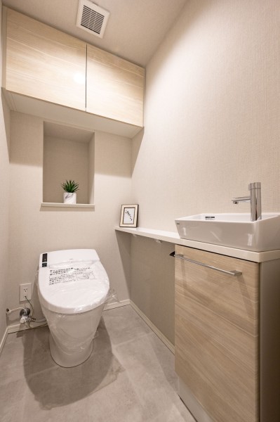 優しい色調で統一された清潔感溢れるレストルームには、タンクレストイレを設置いたしました。また吊戸棚と手洗い場があり、インテリアやフォトフレームなど飾ることができます。タンクのお掃除が不要なトイレです。