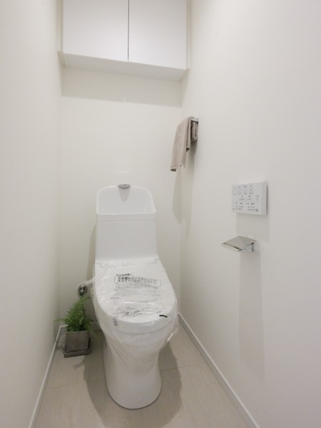 上品さを宿すレストルームには上部吊戸棚収納を設置しています。お掃除用品やペーパー類も収納できるため、足元の空間をすっきりと保ちながらお使いいただけます。