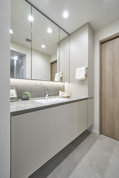 洗面化粧室にはシックなカラーで統一された洗面化粧台と収納棚を設置いたしました。収納棚にはリネン系や日用品など生活リズムに合わせた収納をすることができます。キッチンと同じデザインの映える色合いです。