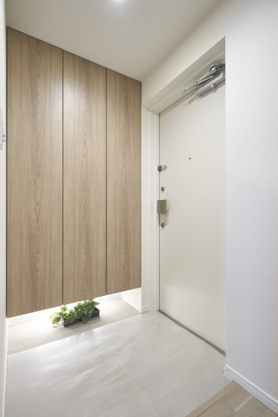 白基調のクロスに映えるグレージュアッシュカラーのシューズボックスはシューズをたくさん収納することができます。その日使用しないシューズや雨具など片づけて玄関を広くお使いいただけます。