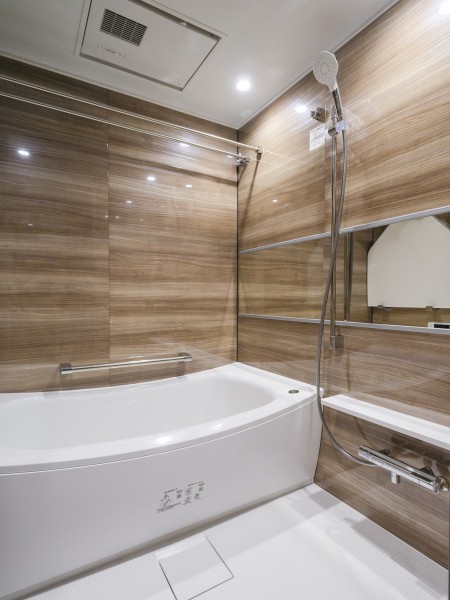 木目調パネルが高級感を漂わせるバスルームは、浴室換気乾燥機付きのゆったりとした空間です。ゆるやかなカーブが特長の浴槽で、心ゆくまでリラクゼーションタイムをお楽しみいただけます。