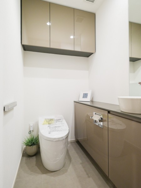 清潔感が溢れ、上品なレストルームにはタンクレストイレと吊戸棚と手洗い場があります。優れた節水効果や汚れが付きにくい便座など、ほしかった機能が揃ったウォシュレット一体型トイレです。