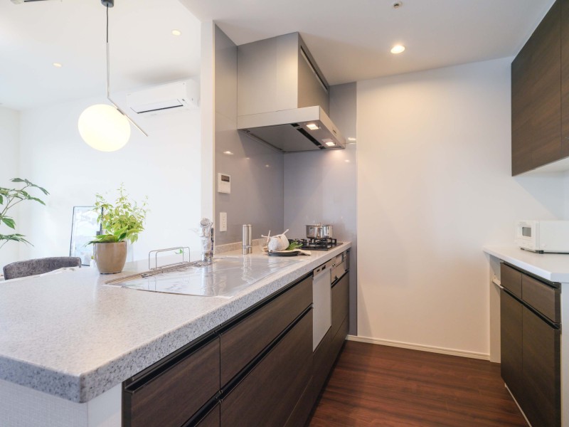 カウンタートップに美しく、メンテナンスも簡単な人工大理石を採用したキッチンです。背面にはキッチンとお揃いでスタイリッシュなカップボードを備え付けております。