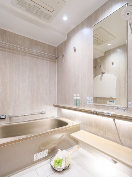 ヘッドレスト付きの浴槽に身を預けながら、肩・腰を心地よく温める「楽湯」がやさしく包むバスルームです。調光調色システムにより、気分に合わせて明かりを切り替えられる、より深いリラックスを味わえる空間です。