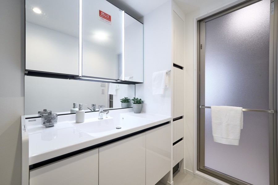 身支度の時間をも快適に彩る、美しく空間に溶け込む洗面化粧台と、右手にはリネン庫も完備しています。収納豊富な三面鏡付きでカウンタースペースにもゆとりのあるため、ドレッサーとしても活躍してくれそうです。