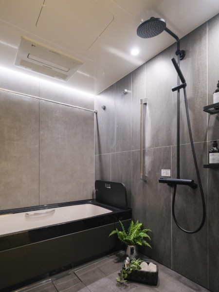 シックな雰囲気のバスルームとなっております。広々としたバスタブが映える色調のタイルを使用し、高級感のある空間となっております。ゆとりのある浴室で、快適なバスタイムをお楽しみいただけます。