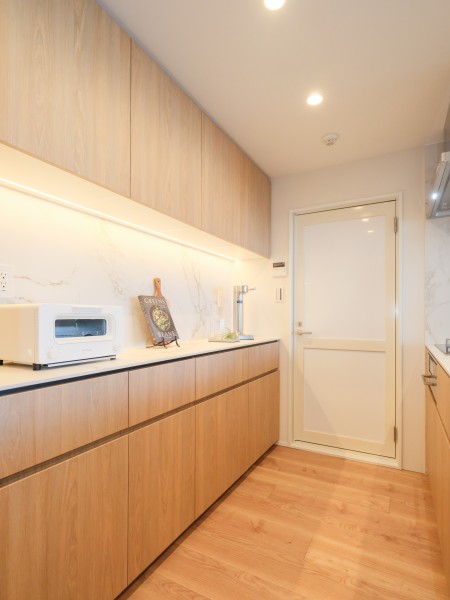 キッチンの背面にはお揃いのデザインのカップボードを設置いたしました。調味料や食器の収納に役立ち、カウンター部分には調理家電やワインなどを置くこともできます。