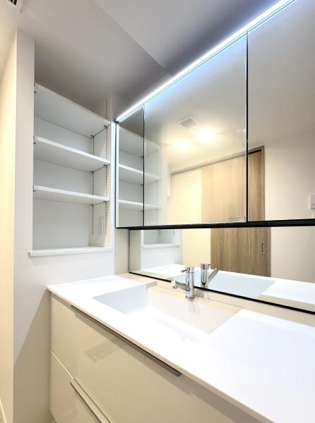 三面鏡裏や足元の収納など使いやすさも兼ね備えている洗面化粧台です。洗面化粧台の隣に棚があり、可動式のため収納アイテムの高さに合わせて調整することができます。