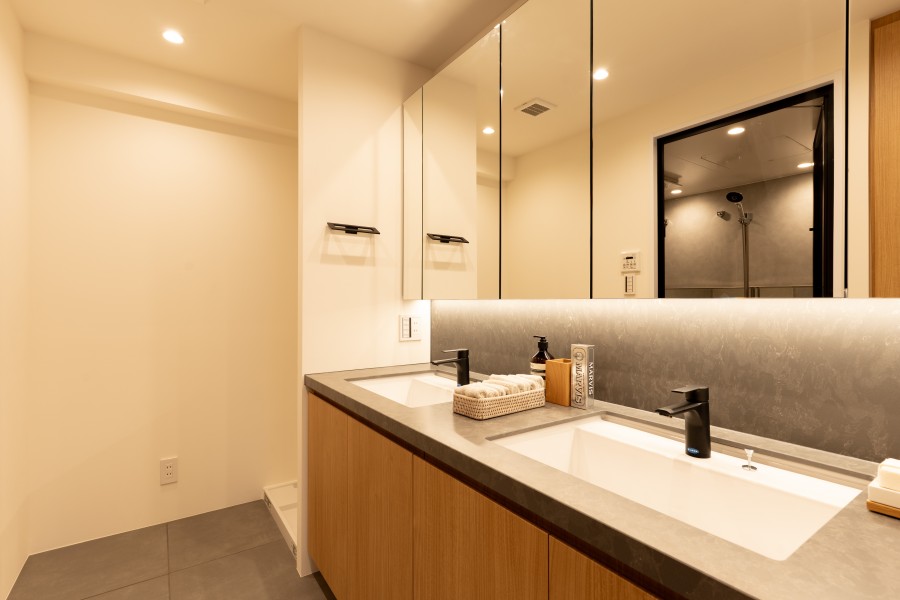 ホテルライクな２ボウル洗面化粧台を採用いたしました。お出かけ前の準備時間を快適にお過ごしいただける嬉しい仕様です。三面鏡裏や足元の収納棚があり、洗面室を広々とお使いいただけます。