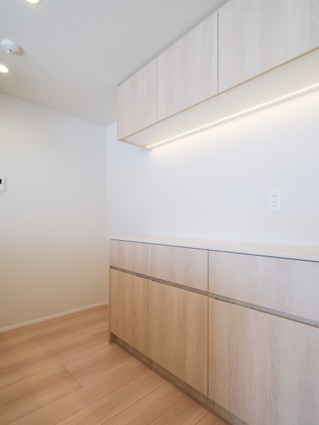 背面にはキッチンとお揃いでスタイリッシュなカップボードを備え付けました。美しい木目の面材はインテリアの一部のようでお部屋の雰囲気に溶け込みます。