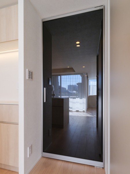リビングへ続く扉はガラス仕様で、空間に開放感と軽やかさを演出します。周囲の素材と調和する仕上げで、住まい全体に落ち着いた雰囲気を添えています