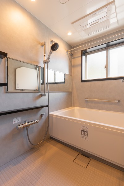 浴室にも窓がある、開放感に溢れた住まいです。柔らかな照明と自然光が溶け合い、心を解き放つ空間。淡いグレーのパネルが一日の疲れを優しく癒してくれます。