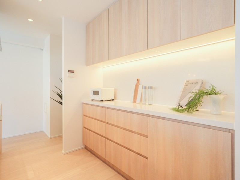 キッチンの背面にはお揃いのカップボードを設置しました。収納豊富でカウンタースペースも広く、実用的です。カウンター部分にはワインやオシャレな家電を置いて、インテリアとしても楽しめます。