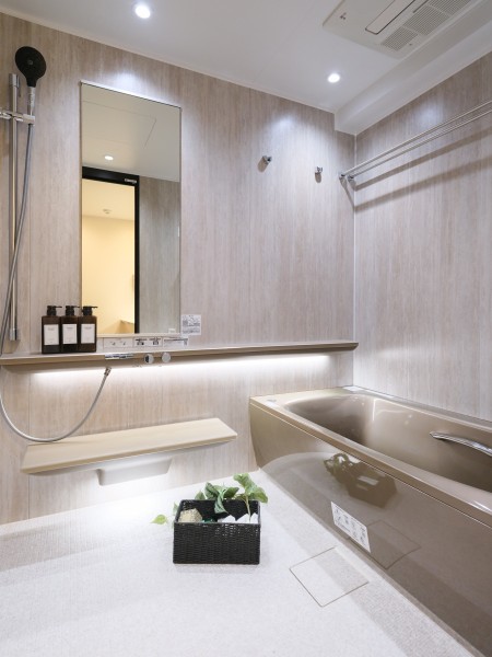 ヘッドレスト付きの浴槽に身を預けながら、肩・腰を心地よく温める「楽湯」がやさしく包むバスルームです。調光調色システムにより、気分に合わせて明かりを切り替えられる、より深いリラックスを味わえる空間です。