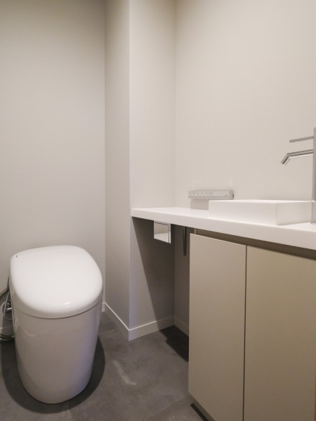 レストルームも水回りの統一感のある空間に仕上げました。タンクレストイレやスティックリモコン、手洗いカウンターなどを設置し、清潔感がありスマートな雰囲気を醸し出します。