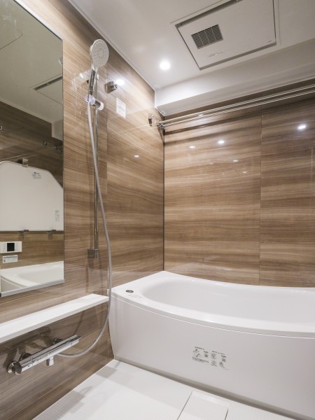 浴槽は美しいカーブと全身を包み込むような入浴感が特長です。光沢のある木目調のパネルが、より一層くつろぎの空間へ誘います。