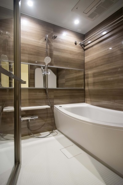 美しいカーブと全身を包み込むような入浴感が特長のクレイドル浴槽を採用しました。光沢のある木目調パネルが高級感を漂わせるバスルームです。