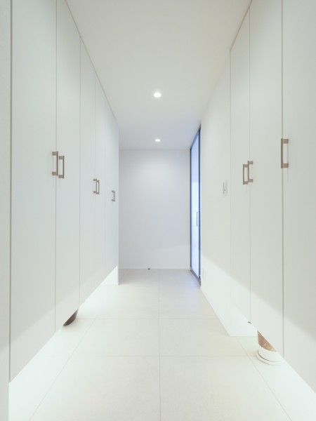 両壁に広がり、天井まで高さのある大容量のシューズクローゼットが、玄関周りを常にスッキリと美しく保ちます。ドアを開けた瞬間に広がる、ミニマルなデザインで統一されたクリーンで開放的な玄関空間です。