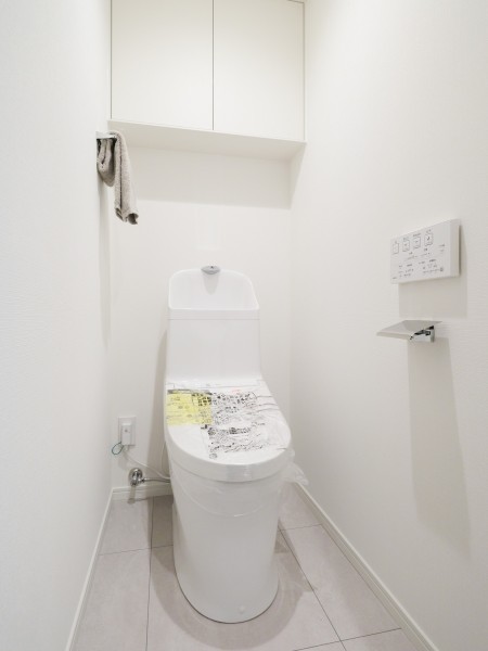 シンプルで安らぎが宿るレストルームです。吊戸棚にはトイレットペーパーや掃除用具を収納できるので便利です。