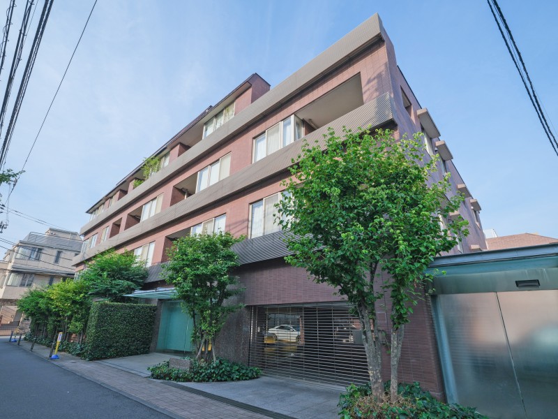 ブラウン系タイルを基調とした落ち着きのある外観です。街路に面して植栽が配されており、周囲の景観と調和した佇まいが印象的です。