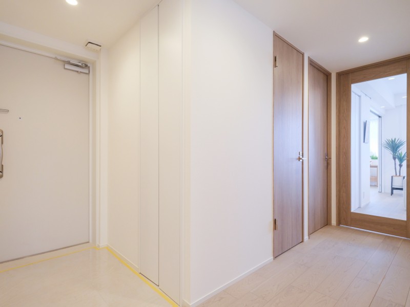 淡い木目が描く温もりと、光を纏う白の美しさが紡ぐ、ほっと一息安らげる居住空間です。ナチュラルカラーで統一された住まいは、シンプルでありながら心を満たす美しさを演出します。