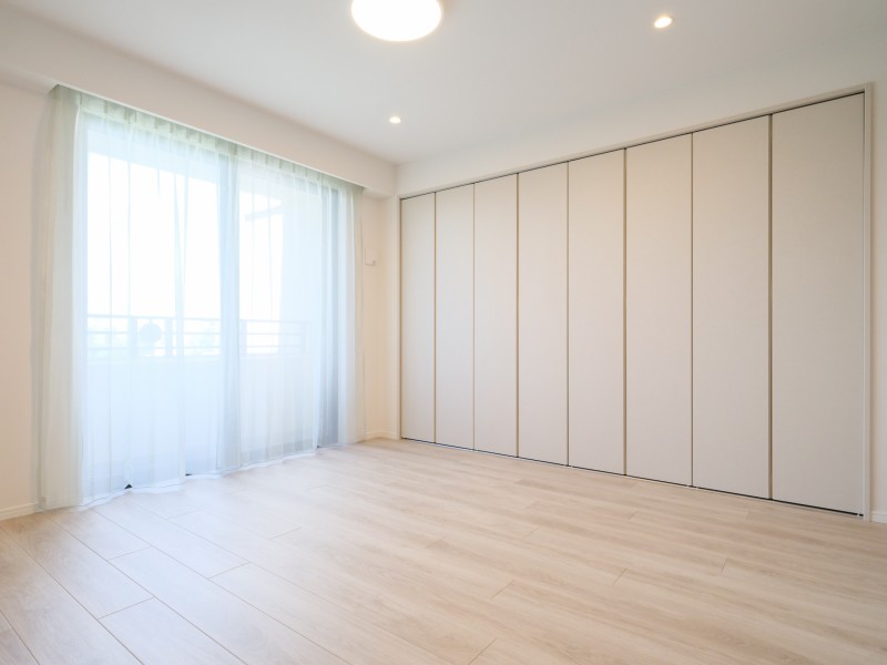 大きな開口部から自然光を取り込みやすい洋室1です。壁一面の収納を備え、居住空間を有効に活用できるレイアウトです。