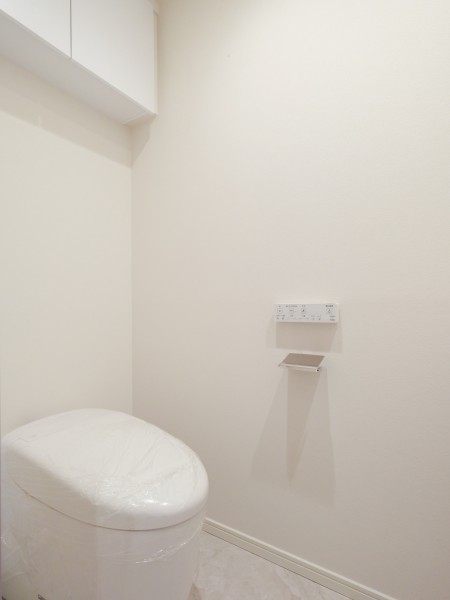 洗浄便座付きトイレを新規交換。上部収納を備えており、生活用品のストックをまとめて収納しやすいシンプルな空間です。
