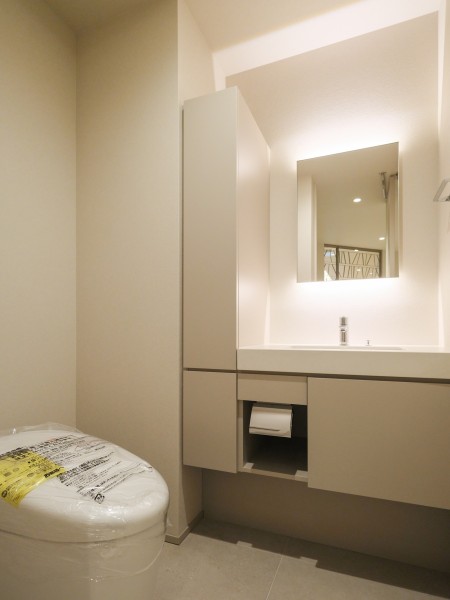 玄関近くに配置されたトイレです。手洗いカウンターと収納を備えた機能的な設計で、来客時にも使いやすい独立した空間です。